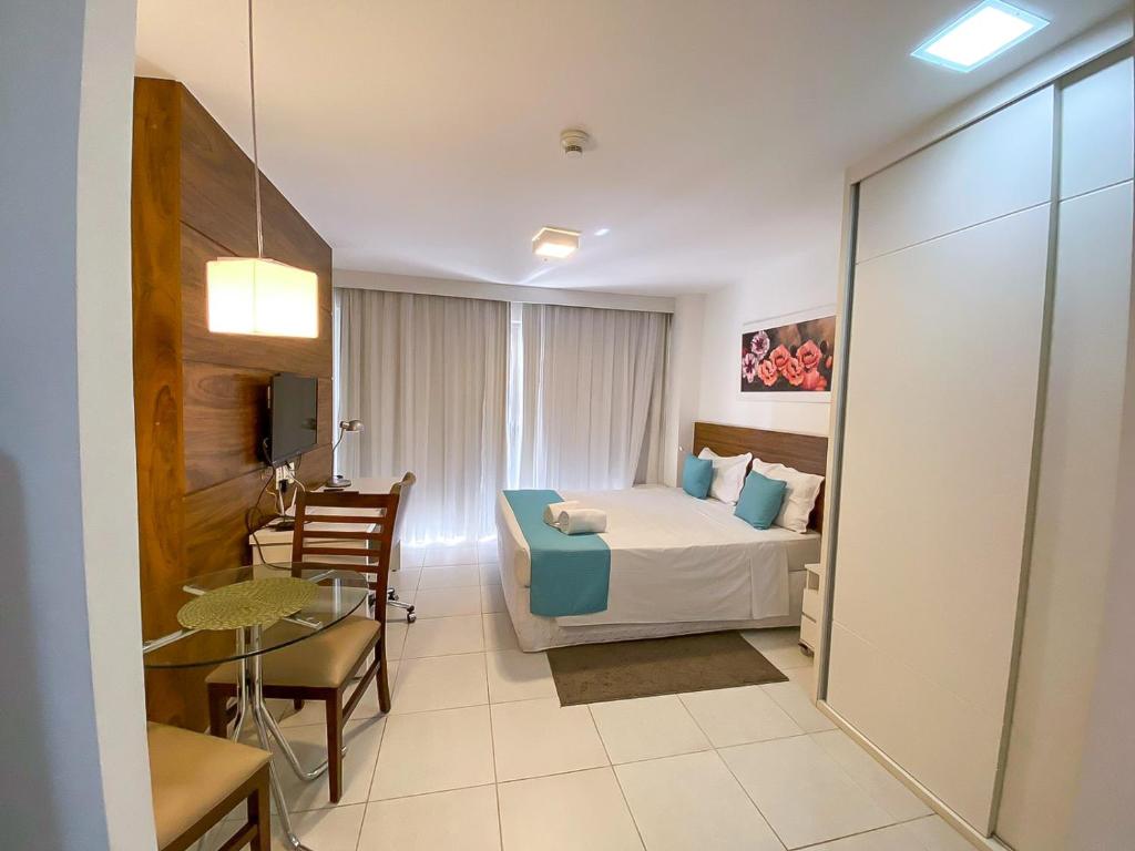 ein Hotelzimmer mit einem Bett und einem Tisch in der Unterkunft Fusion Acomodação Particular na Asa Norte ao Lado do SHOPPING CONJUNTO NACIONAL com Garagem - 7º andar in Brasilia