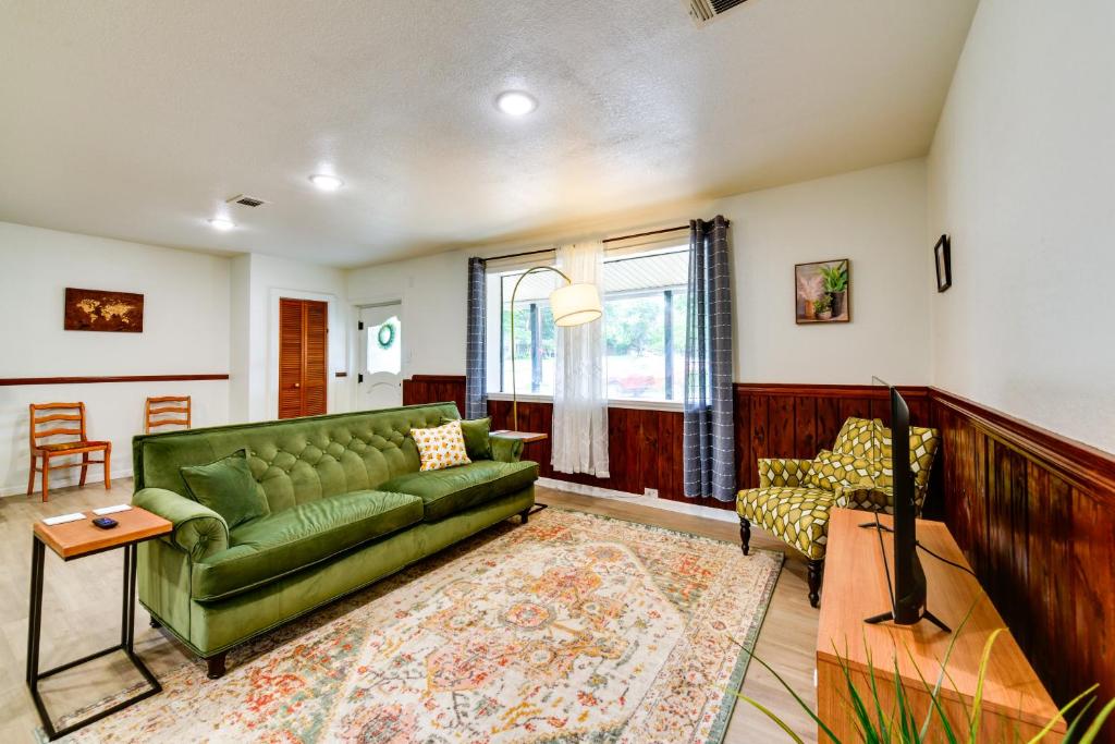 a living room with a green couch and a table at Jonesboro Retreat Near Arkansas State University! in Jonesboro