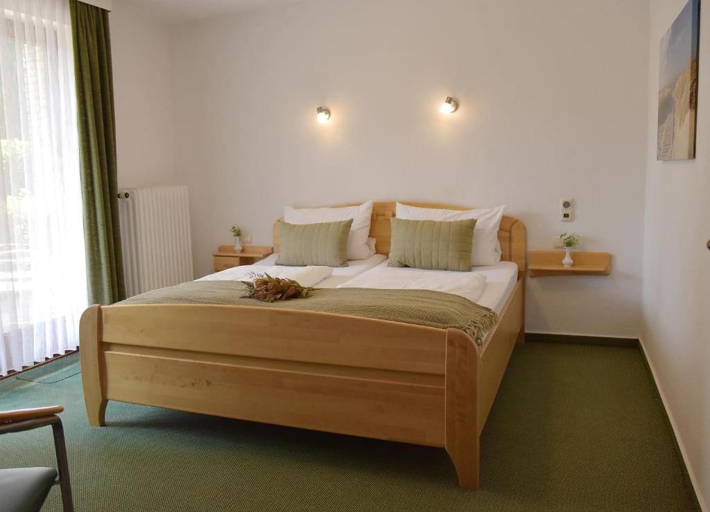sypialnia z dużym drewnianym łóżkiem w pokoju w obiekcie Pension Haus Bambi w mieście Mölln