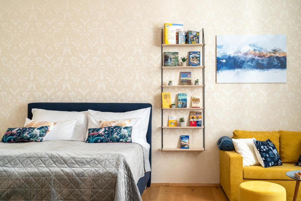 a bedroom with a bed and a yellow chair at Apartment Amélie in Karlovy Vary