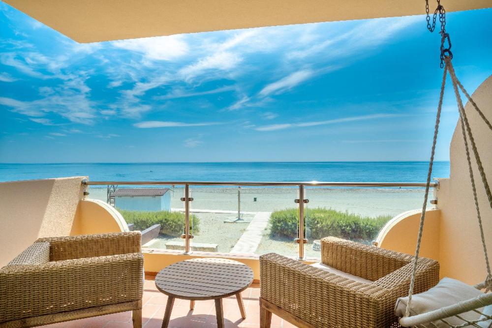 uma varanda com cadeiras e vista para a praia em EL DIAMANTE em Casares