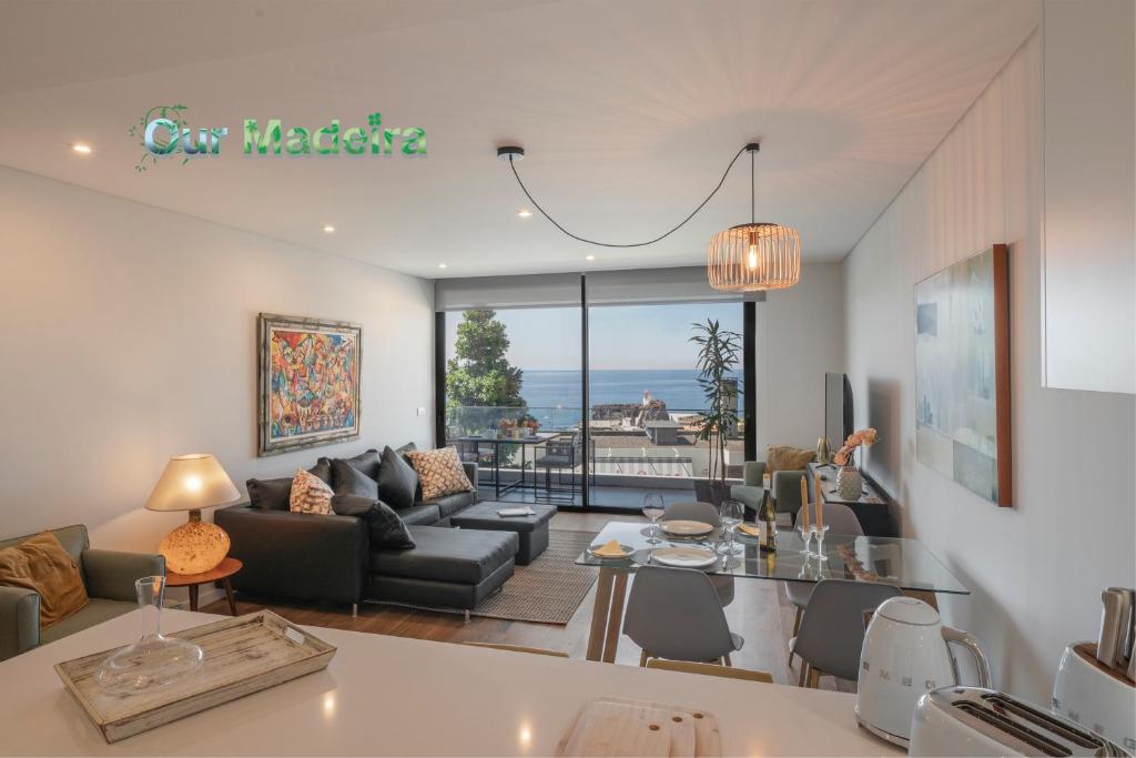 een woonkamer met een bank en een tafel bij OurMadeira - Bayside Apartment in Câmara de Lobos