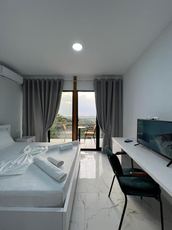 a bedroom with a bed and a desk with a computer at Restorant Hotel Xheni in Durrës