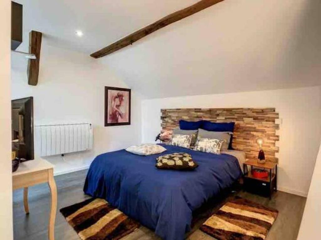 1 dormitorio con 1 cama azul y TV en Suzy home, en Moisenay