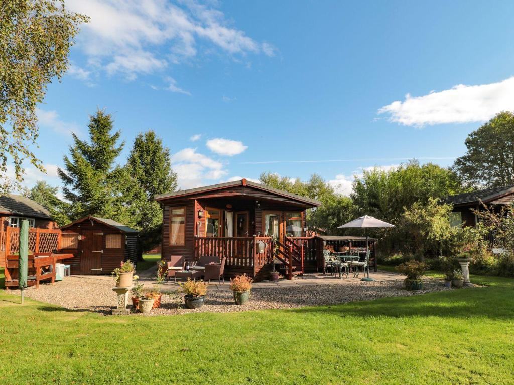 モーペスにあるEvergreen Lodgeの草の庭のある森のキャビン