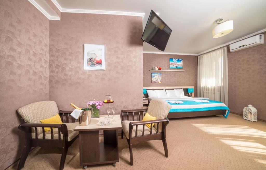 a hotel room with a bed and a table and chairs at Milotel Margarita in Anapa