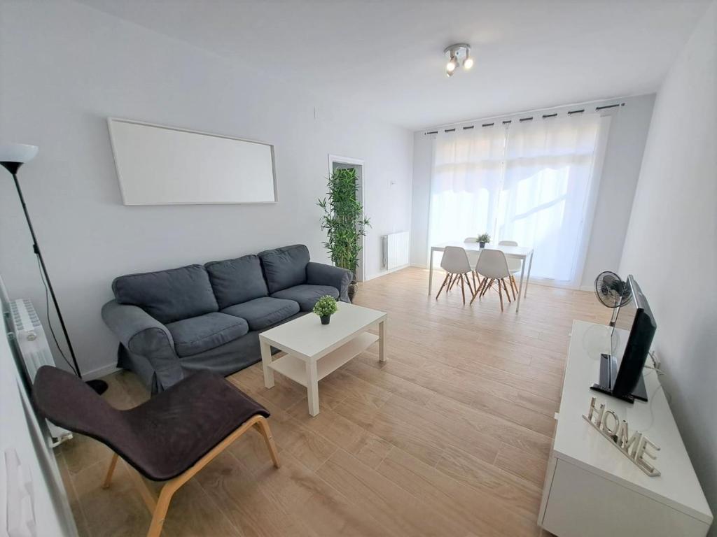 a living room with a blue couch and a table at Sant Jordi Pisos - Dos de Maig in Barcelona