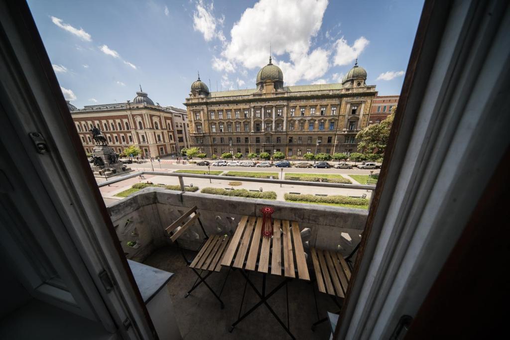 una panchina seduta di fronte a un grande edificio di Roller Aparthotel a Cracovia