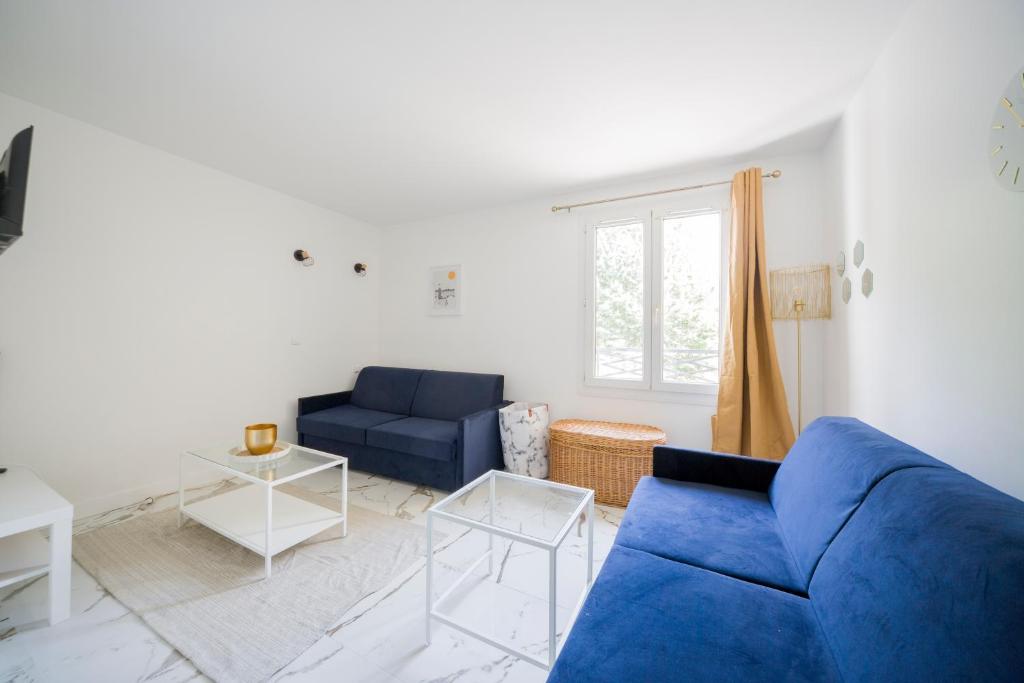 ein Wohnzimmer mit einem blauen Sofa und einem Fenster in der Unterkunft Studio - Luxury Home in Bussy-Saint-Georges