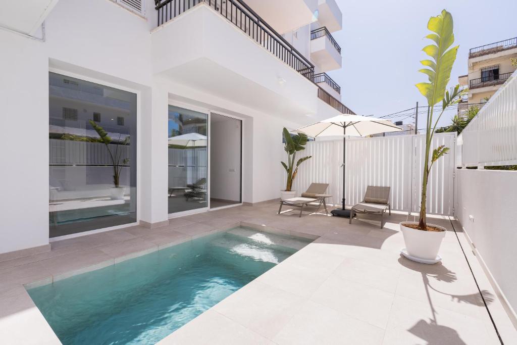 basen na podwórku domu w obiekcie Bossa Bay Suites with Private Pool - MC Apartments Ibiza w mieście Ibiza
