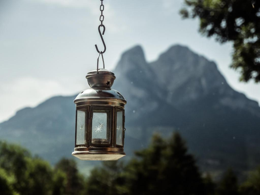 a lantern hanging from a chain with mountains in the background at Ca l'Andreu in Saldés
