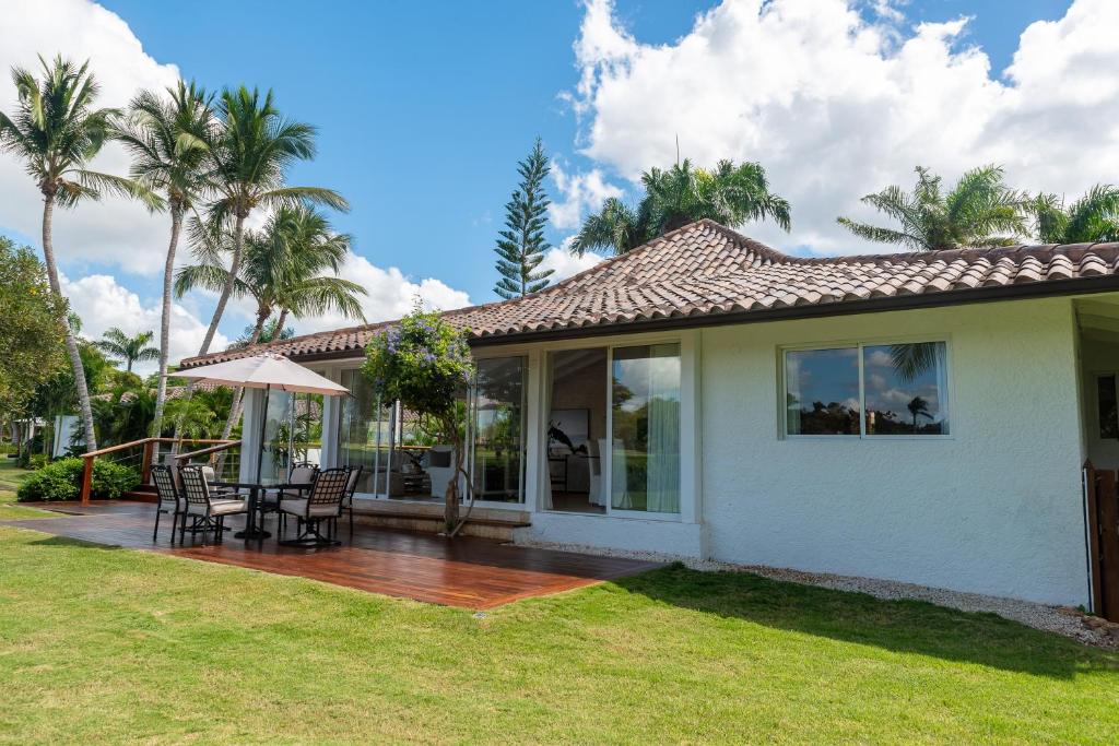 Casa con terraza con mesa y sillas en Family-Friendly 4-Bedroom Golf Villa with Private Pool, Jacuzzi, and Golf Cart, en La Romana