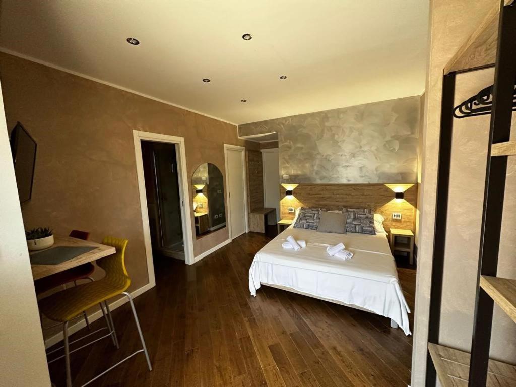 una camera con letto bianco, tavolo e sedia di Casa Catone (affitta camere) a Monte Porzio Catone