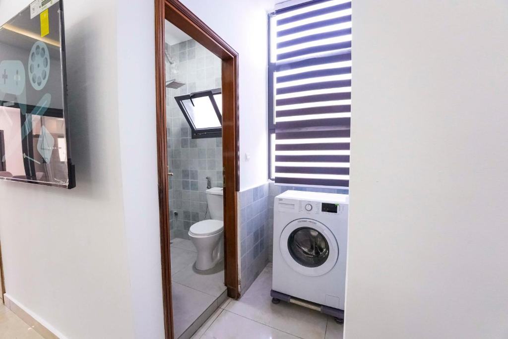 a bathroom with a washing machine and a mirror at TERANGA IMMO LUXE in Dakar