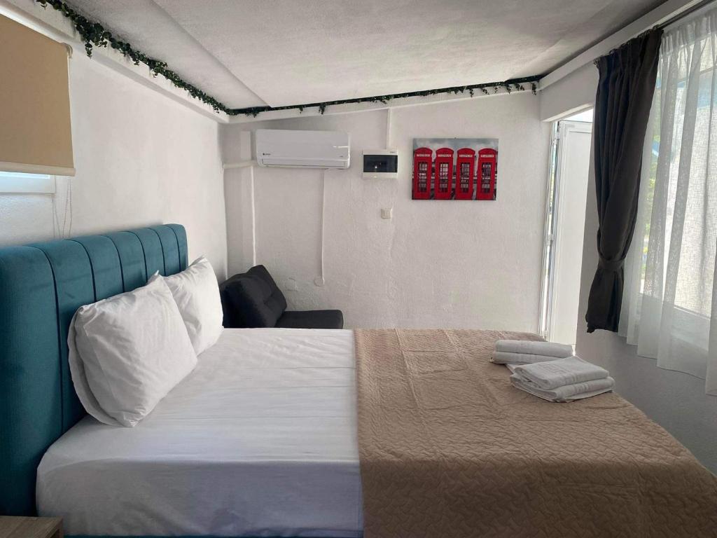 1 dormitorio con 1 cama grande y cabecero azul en STUDIOS TASOS BI, en Chrysi Ammoudia