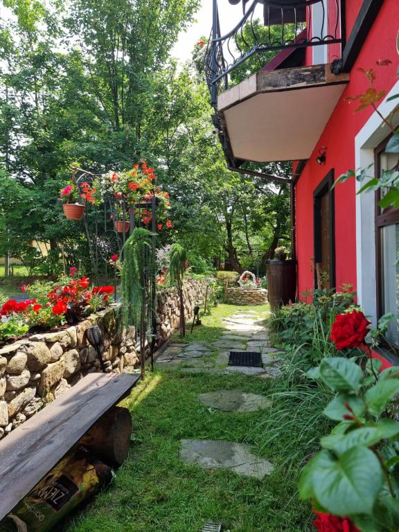 a garden with flowers and a bench next to a building at Apartamenty u Bodzia in Stronie Śląskie