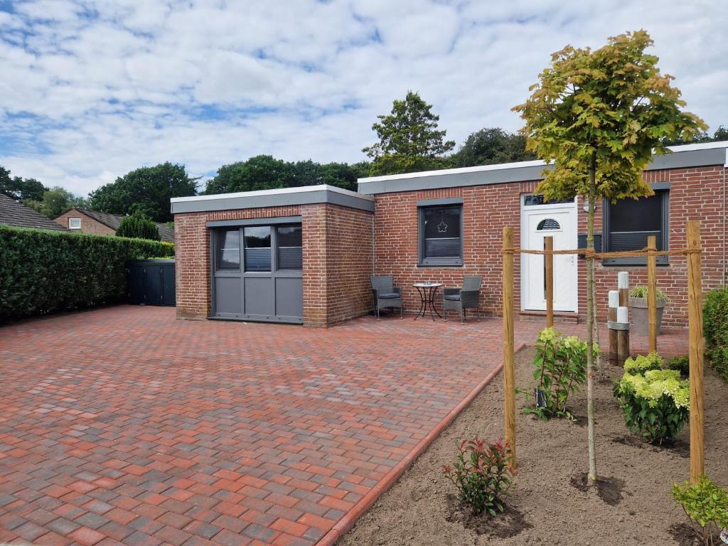 a brick house with a brick driveway at Ferienhaus Nordseeglück im Ferienpark Berumbur in Berumbur