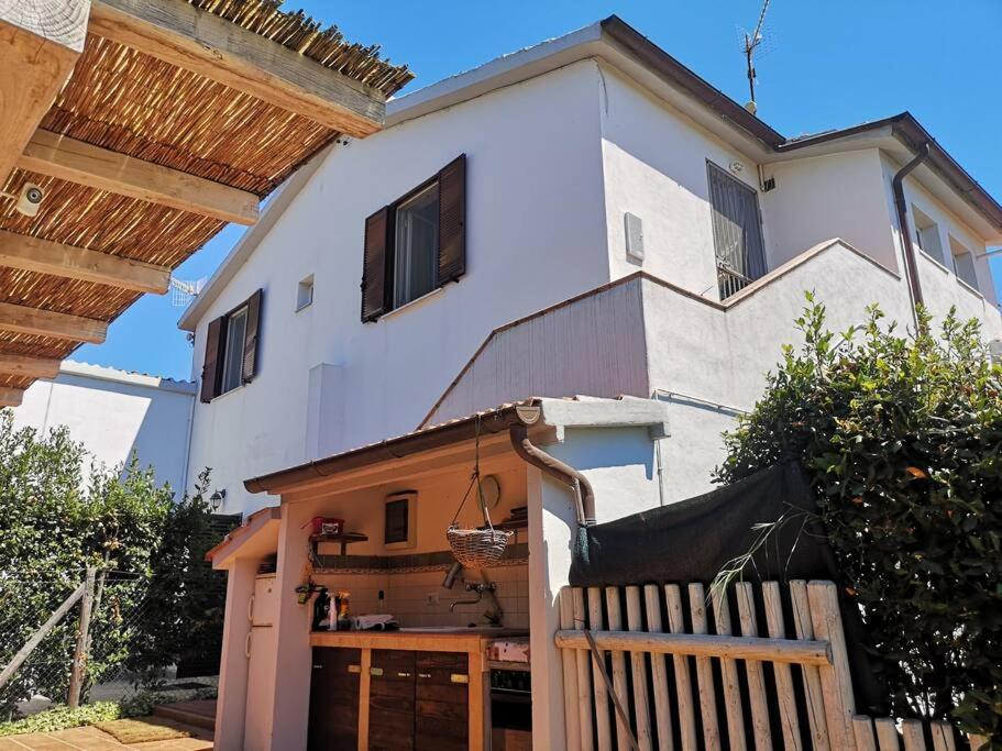 una casa blanca con una valla de madera delante de ella en Deliziosa Porzione di Casale, en Pescia Romana