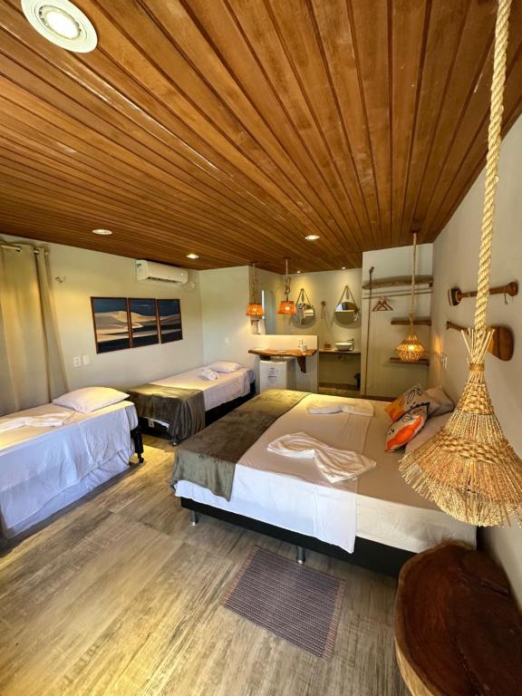 アチンスにあるLa Paz Village Atinsの木製の天井が特徴のベッドルーム1室(ベッド2台付)