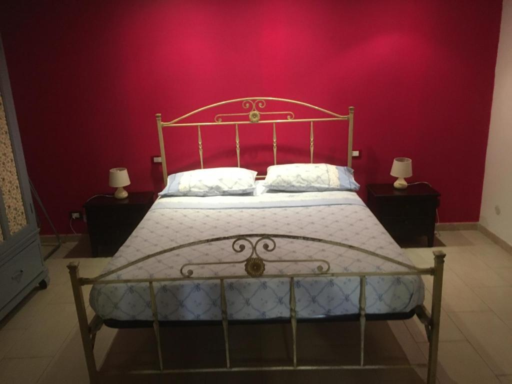 a bedroom with a bed with a pink wall at Casa Movida in Trapani
