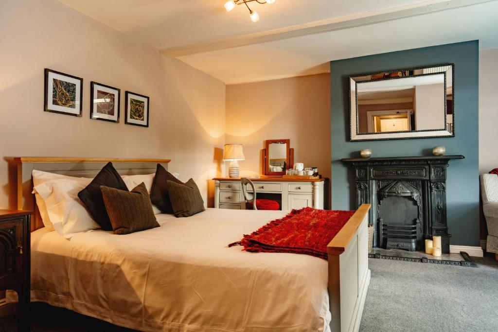 a bedroom with a bed with a fireplace and a mirror at Wheatacre White Lion in Burgh Saint Peter