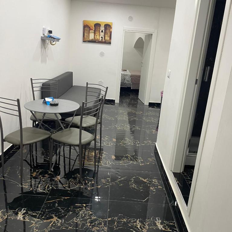 a dining room with a table and chairs on a black tile floor at Cuore di Napoli in Naples