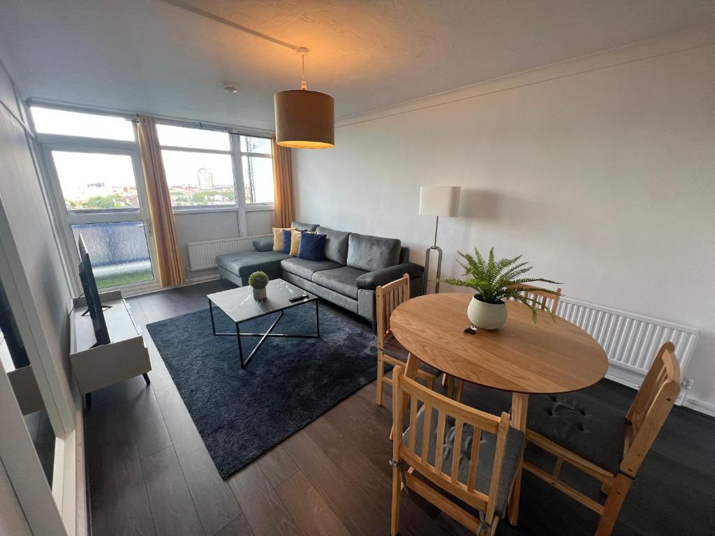 a living room with a couch and a table at New Tower Bridge , Canada Water 2 bedroom flat with a view in London