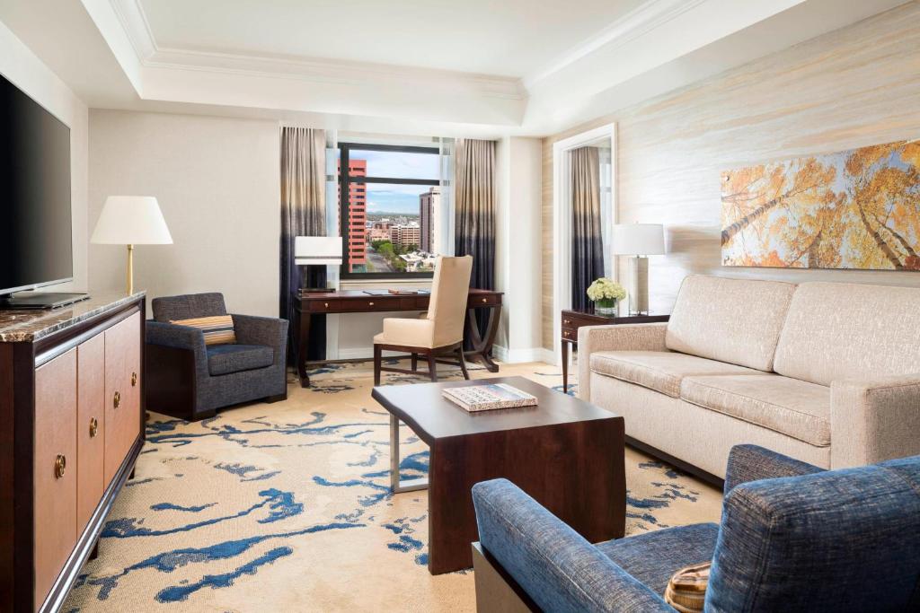 a living room with a couch and a television in a hotel room at The Ritz-Carlton, Denver in Denver