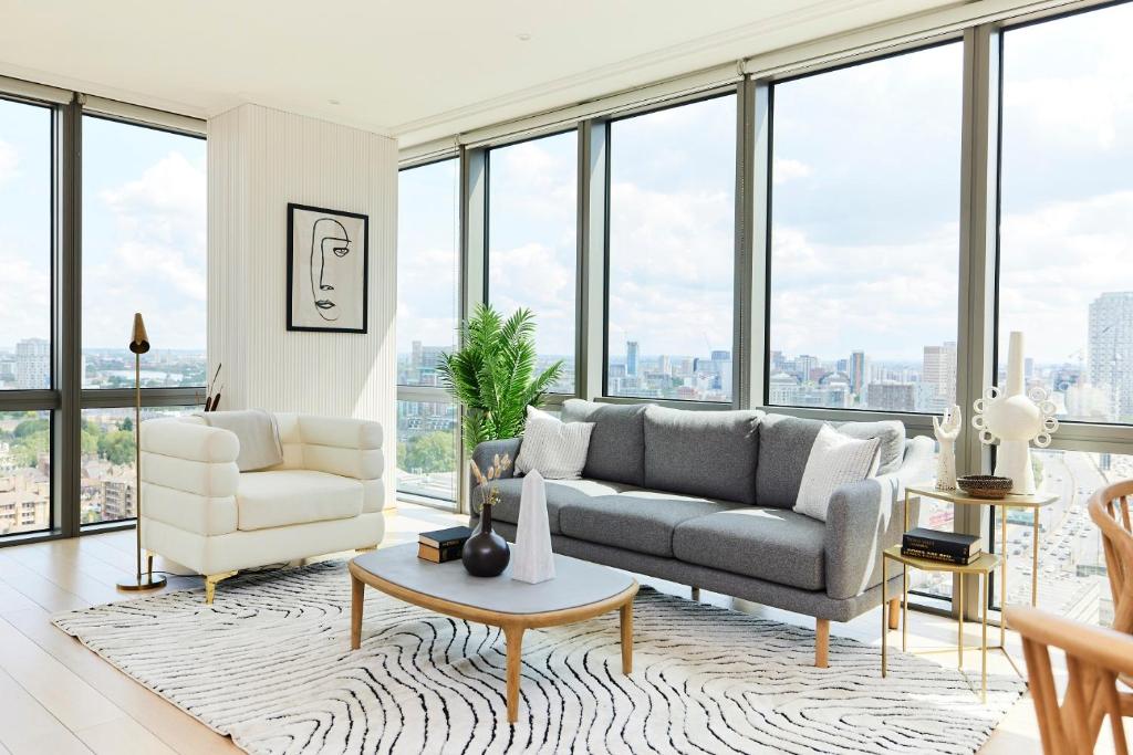 sala de estar con sofá, sillas y ventanas en The Canary Wharf Place - Stunning 2BDR Flat en Londres