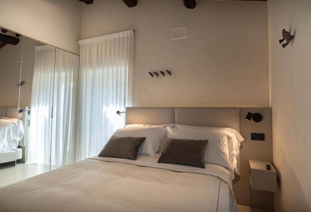 1 dormitorio con 1 cama blanca grande y 2 almohadas en Xenios Assisi en Assisi