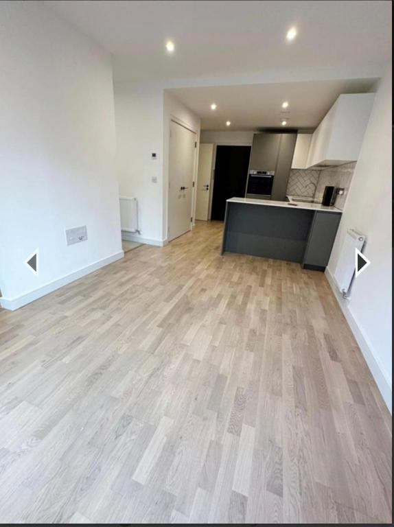 een lege woonkamer met een houten vloer bij Studio flat greenleaf walk in Southall