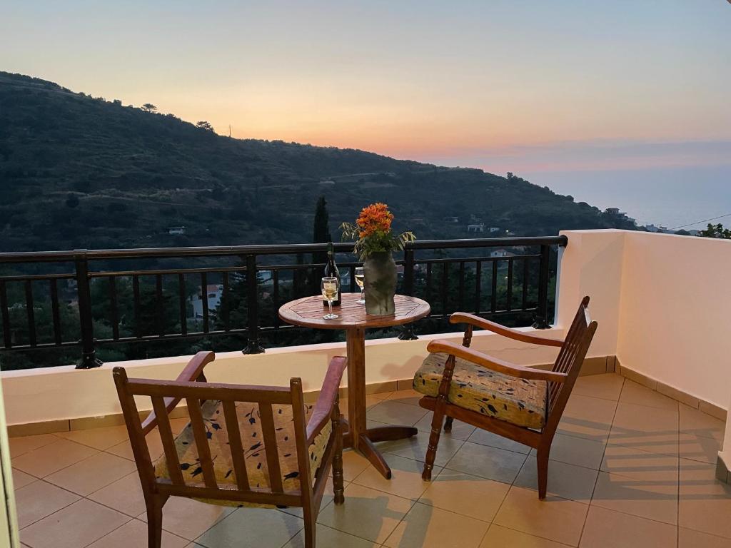 a table and chairs on a balcony with a view at Loukas Apartments in Karavostamo