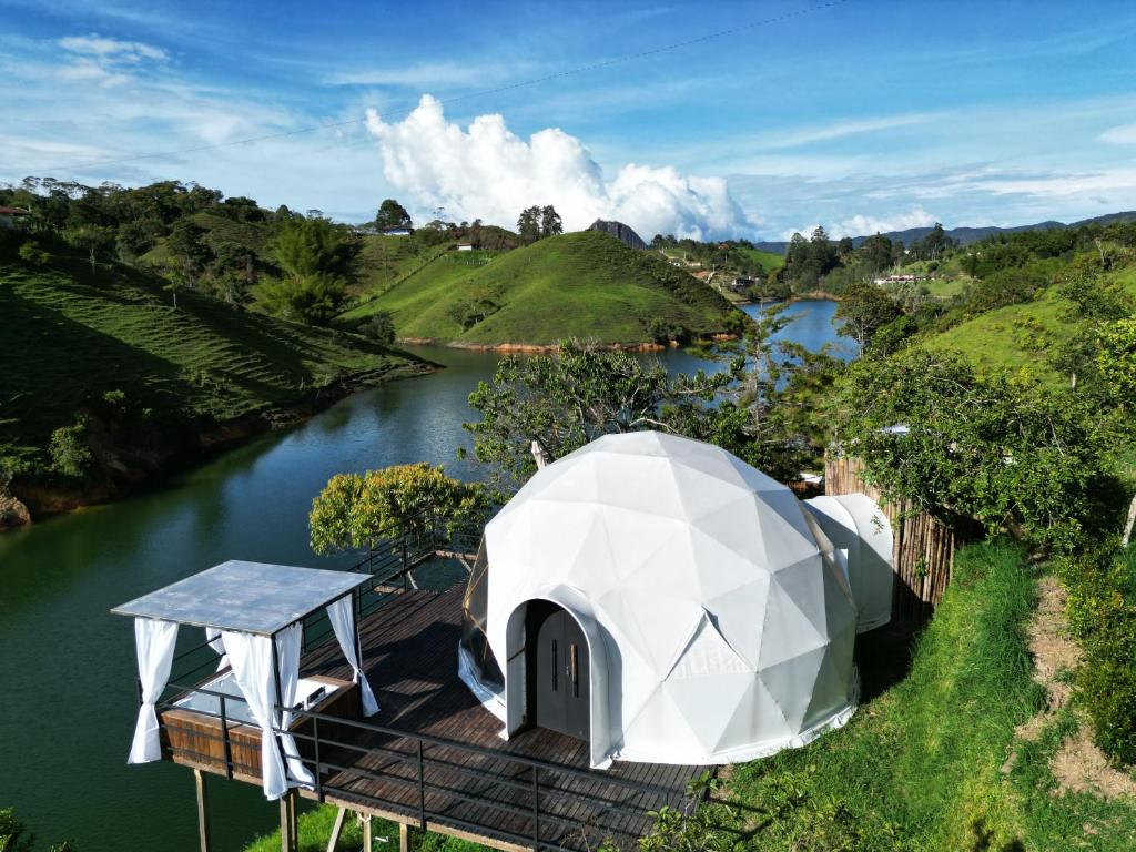 Une tente en forme de dôme à côté d'une rivière dans l'établissement Elysium Glamping, à Guatapé