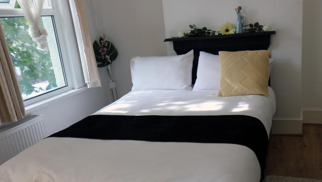 uma cama num quarto com uma janela em cozy rooms in London Townhouse fast links to Central em Londres