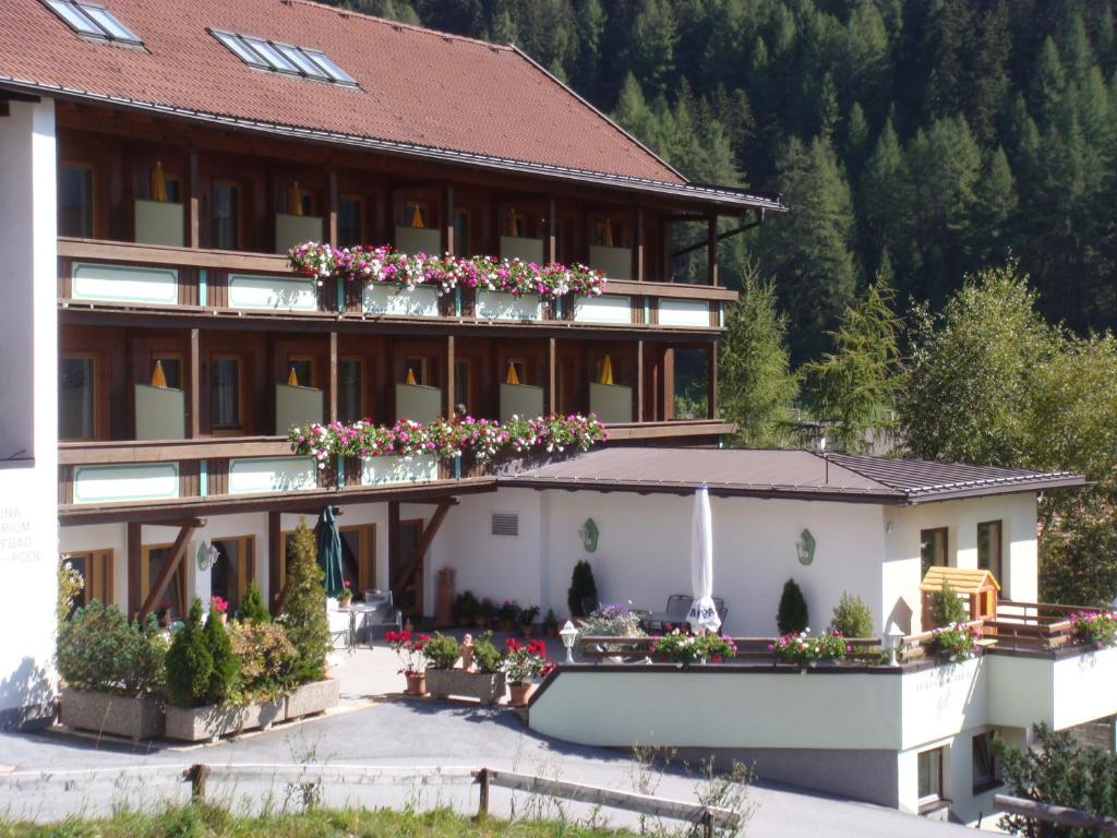 a hotel with flowers on the balconies of it at Hotel Garni Hainbacherhof in Sölden