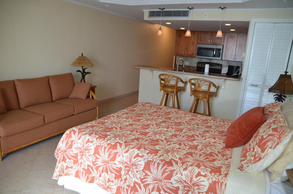 a living room with a bed and a couch and a kitchen at Mahana Resort 612 in Kahana