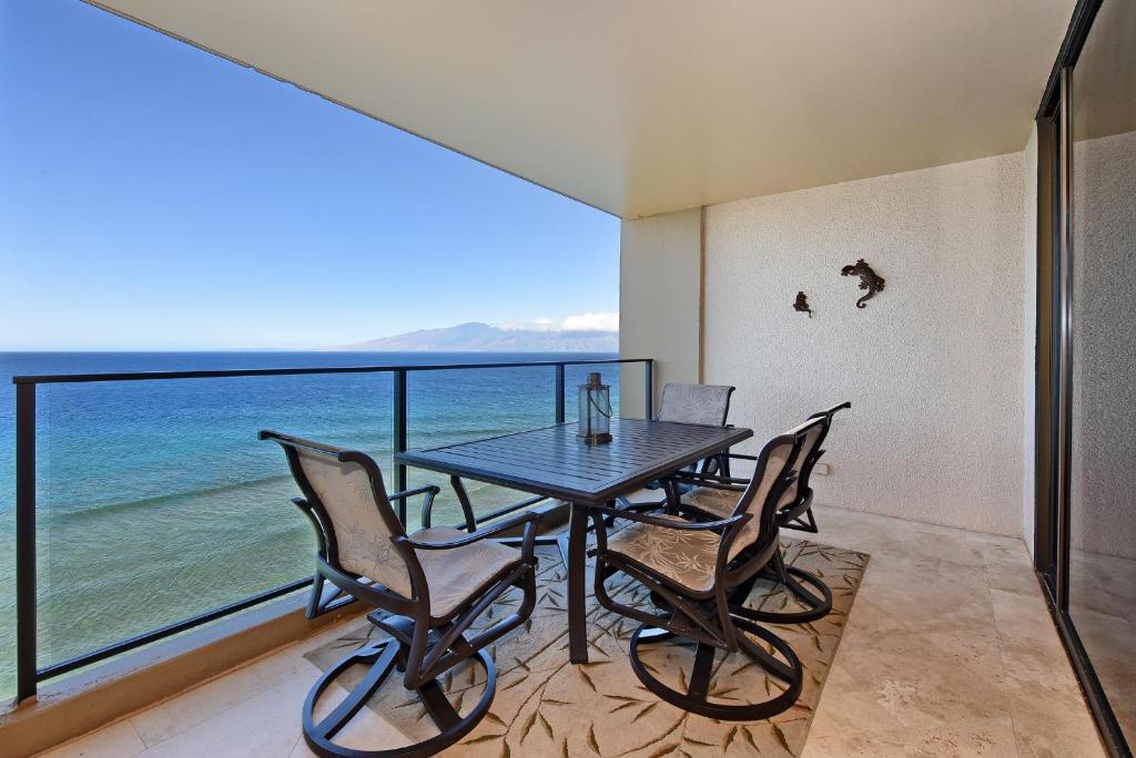 a dining room with a table and chairs and the ocean at Mahana Resort #1204 in Kahana