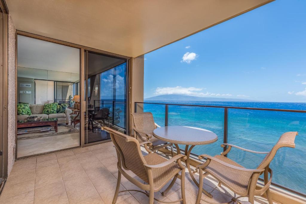 a balcony with a table and chairs and the ocean at Mahana Resort #1017 in Kahana