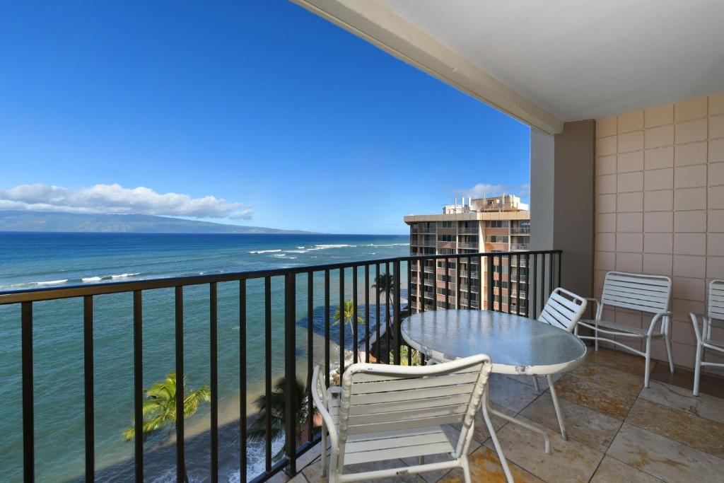 a balcony with a table and chairs and the ocean at Valley Isle 1206 in Kahana