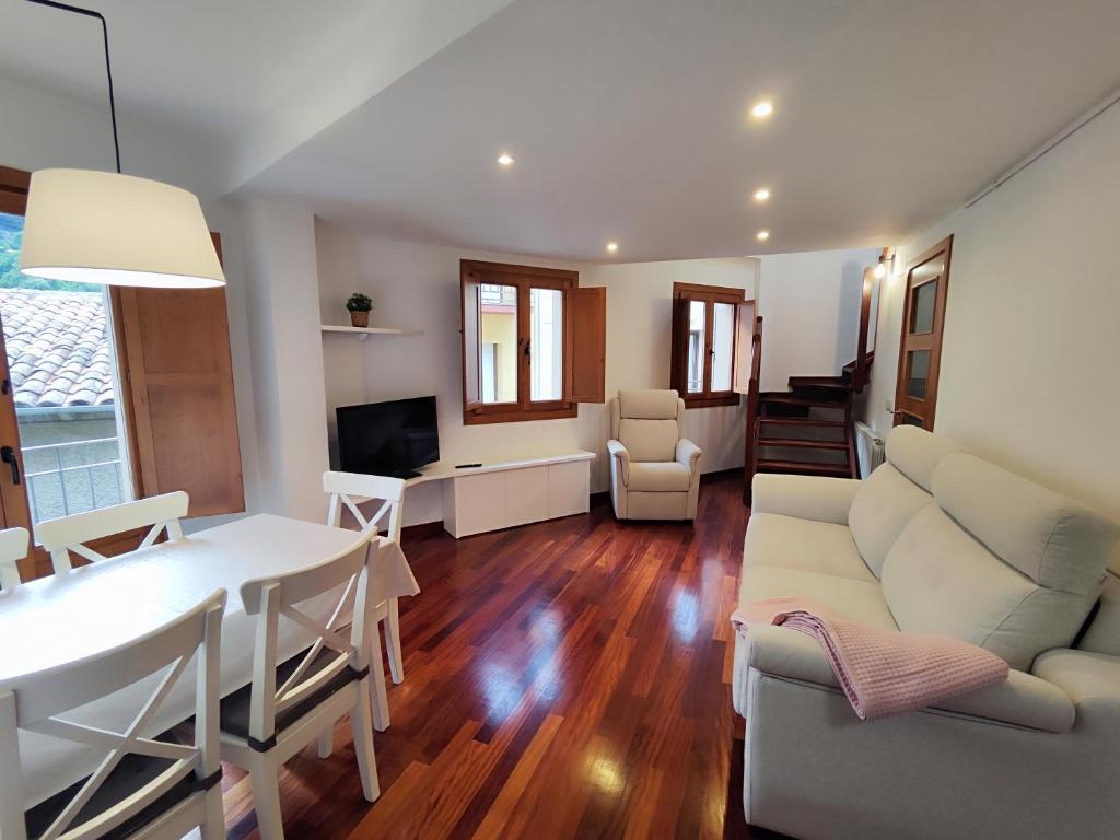 ein Wohnzimmer mit einem weißen Sofa und einem Tisch in der Unterkunft Can Manén in Camprodon