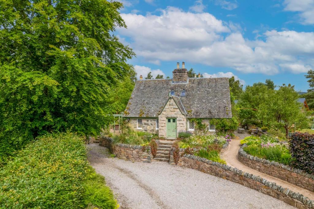 an old stone house with a stone wall at The Polchar - Aviemore in Aviemore