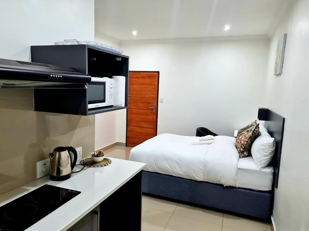 Habitación pequeña con cama y cocina en Maison Akiba en Pretoria