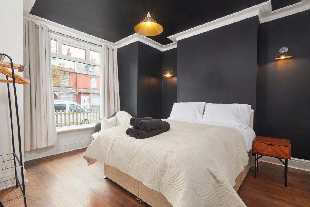 a bedroom with a bed with white sheets and a window at Victoria House in Leeds