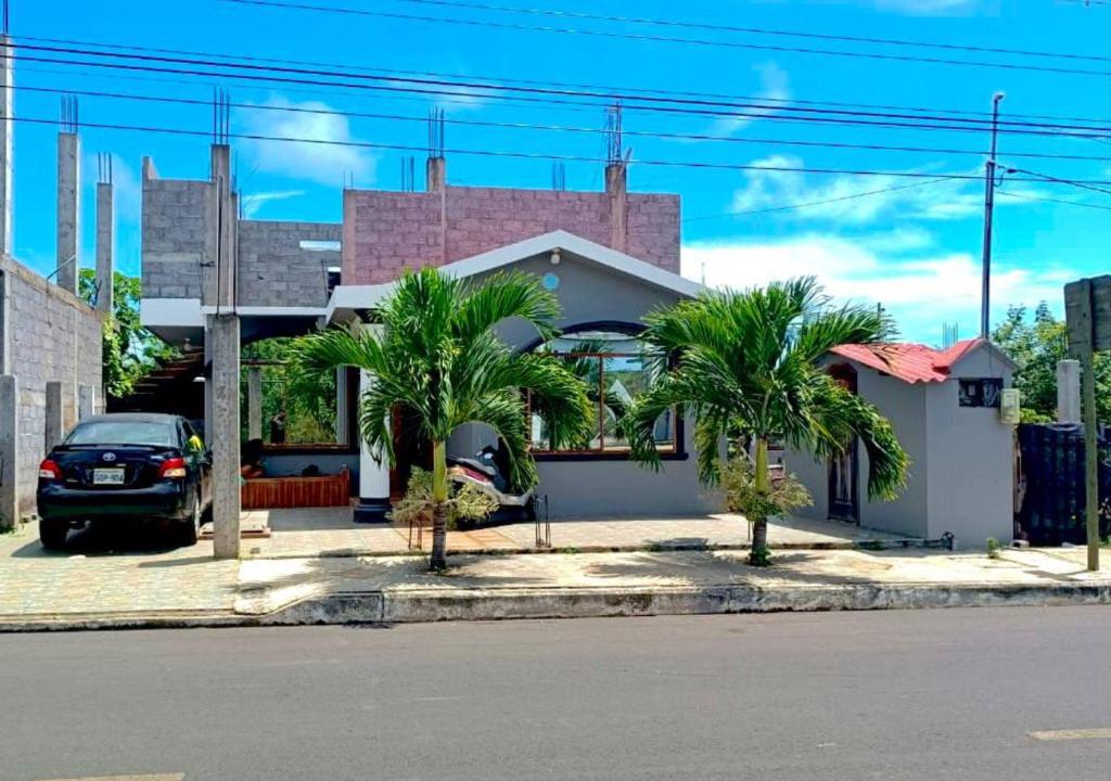 a car parked in front of a house with palm trees at Tropical Paradise, Galápagos in Puerto Baquerizo Moreno
