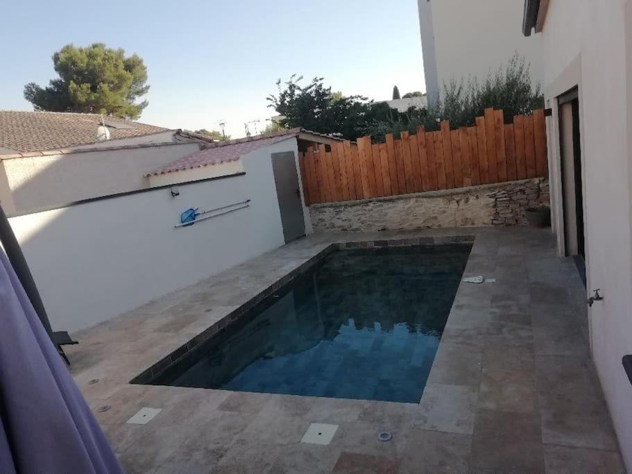 a swimming pool in the backyard of a house at Villa 110m2, 3 chambres, piscine. in Uchaud