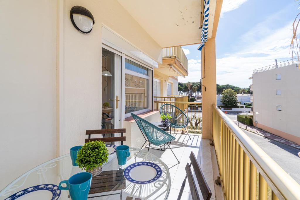 balcón con mesa, sillas y reloj en Coastal Paradise & Cozy Home with a 150m from the Beach! en Cambrils