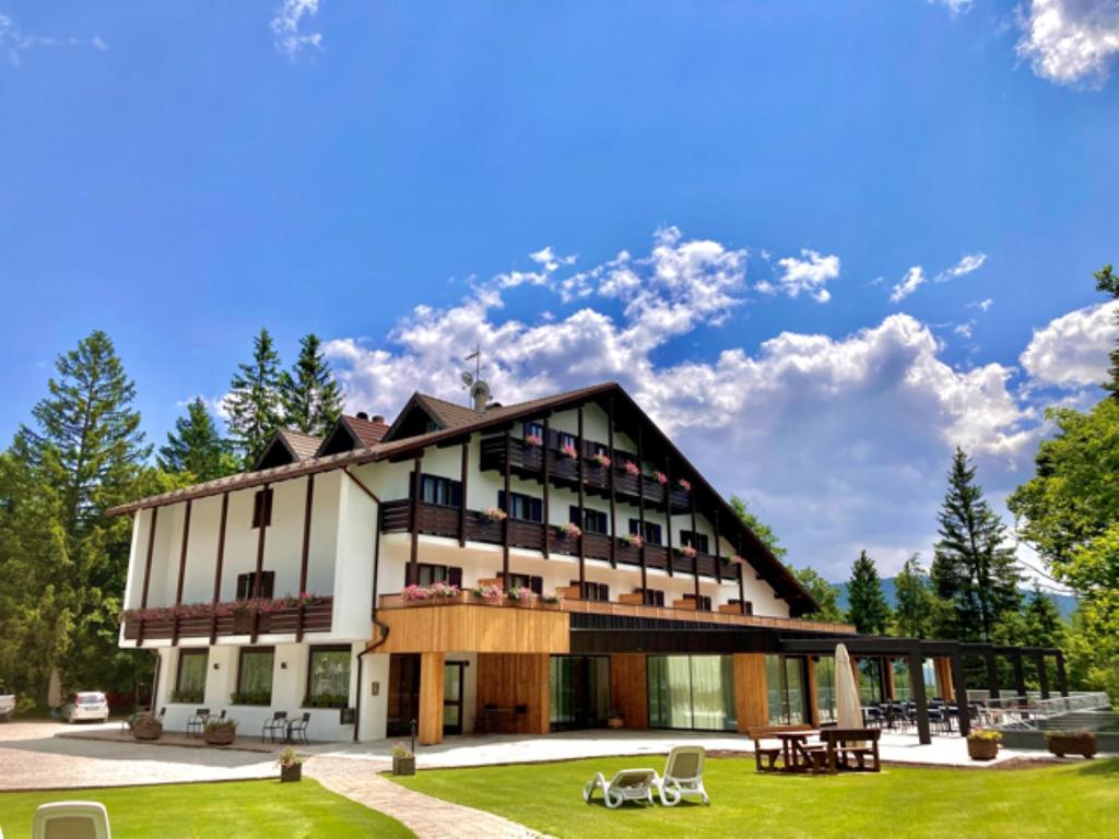 a large building with a lawn in front of it at Hotel Piccola Baita in Molveno