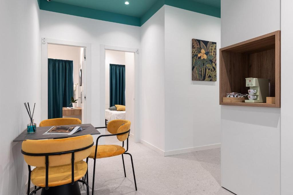une salle à manger avec une table et des chaises jaunes dans l'établissement Nimar Suite, à Formia