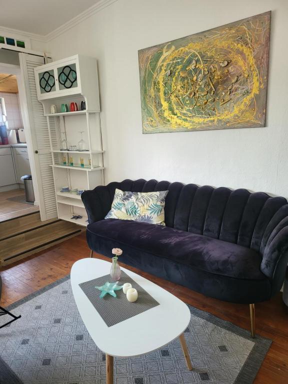 un soggiorno con divano viola e tavolo di Fewo Meerestraum a Wilhelmshaven