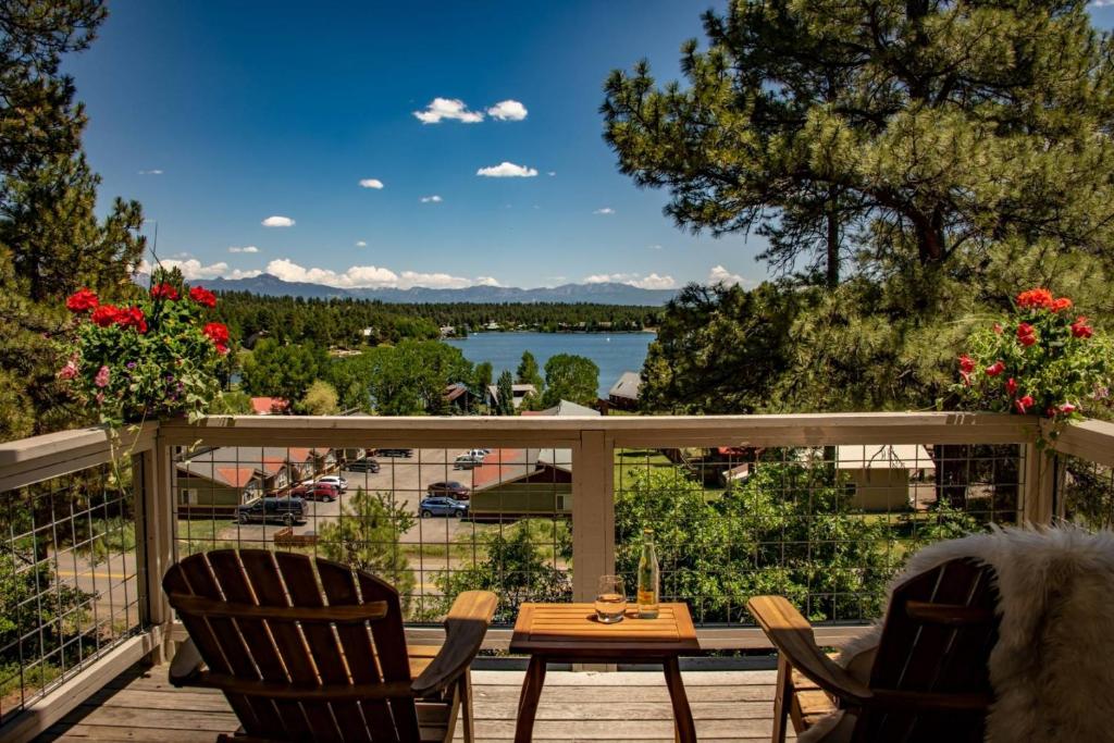 a deck with chairs and a table and a view of a lake at 785 Aspenglow Blvd ("Bear's Cliff") in Pagosa Springs